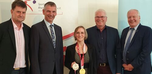 Sportschützin Natascha Hiltrop präsentiert ihre Medaillen. Sportkreisvorsitzender Markus Jestaedt, Landrat Frank Kilian, Werner Koch vom Sportkreis und Sport-Dezernent Hans Rodius (von links) gratulieren Natascha Hiltrop zu deren Erfolg.