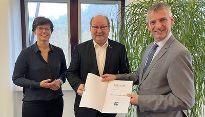 Landrat Frank Kilian (r.) und Antje Schulz, Leiterin des Fachdienstes Umwelt, überreichen Christoph Presser die Urkunde.