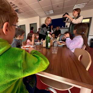 Kinder im Klassenraum, Fotografen mit Kamera in der Hand.