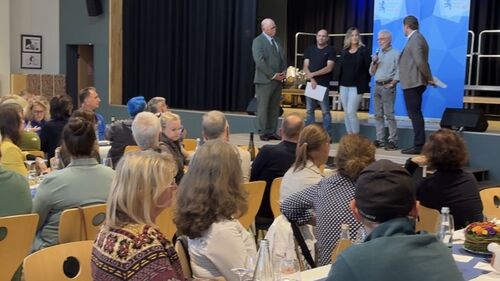 Landrat Sandro Zehner und Dezernent Thomas Zarda mit Bürgern auf der Bühne.