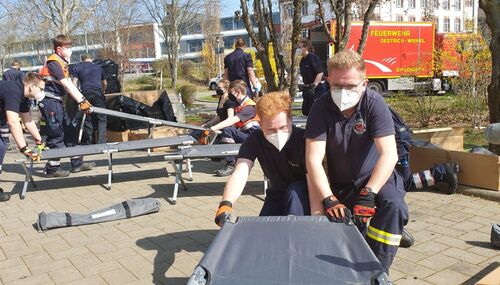 Ehrenamtliche Helfer bauten die Feldbetten vor der Sporthalle der Rheingauschule in Geisenheim auf.