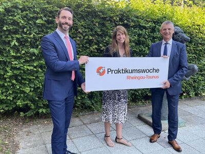 Landrat Frank Kilian, Jennifer Brötz und Ralf Bachmann halten gemeinsam ein Werbeschild der Praktikumswoche.