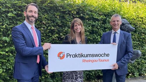 Landrat Frank Kilian, Jennifer Brötz und Ralf Bachmann halten gemeinsam ein Werbeschild der Praktikumswoche.