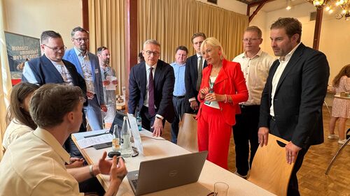 Foto: Foto (v.l.n.r.): Bundesdigitalminister Dr. Karsten Wildberger, Staatsministerin Professor Dr. Kristina Sinemus und Sandro Zehner, Landrat Rheingau-Taunus-Kreis, am Tisch mit einem Pc.